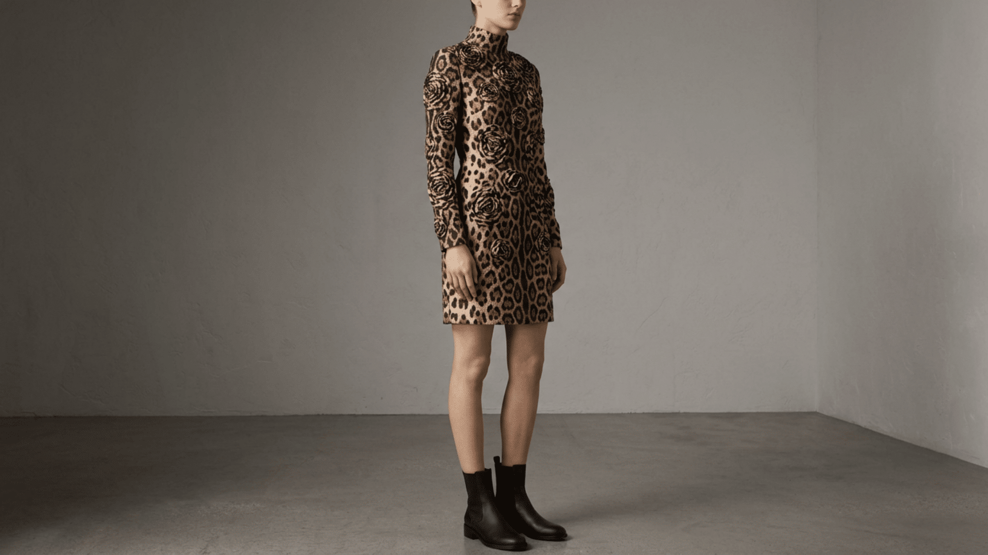 Model wearing leopard print dress showing rosette pattern detail in studio settin