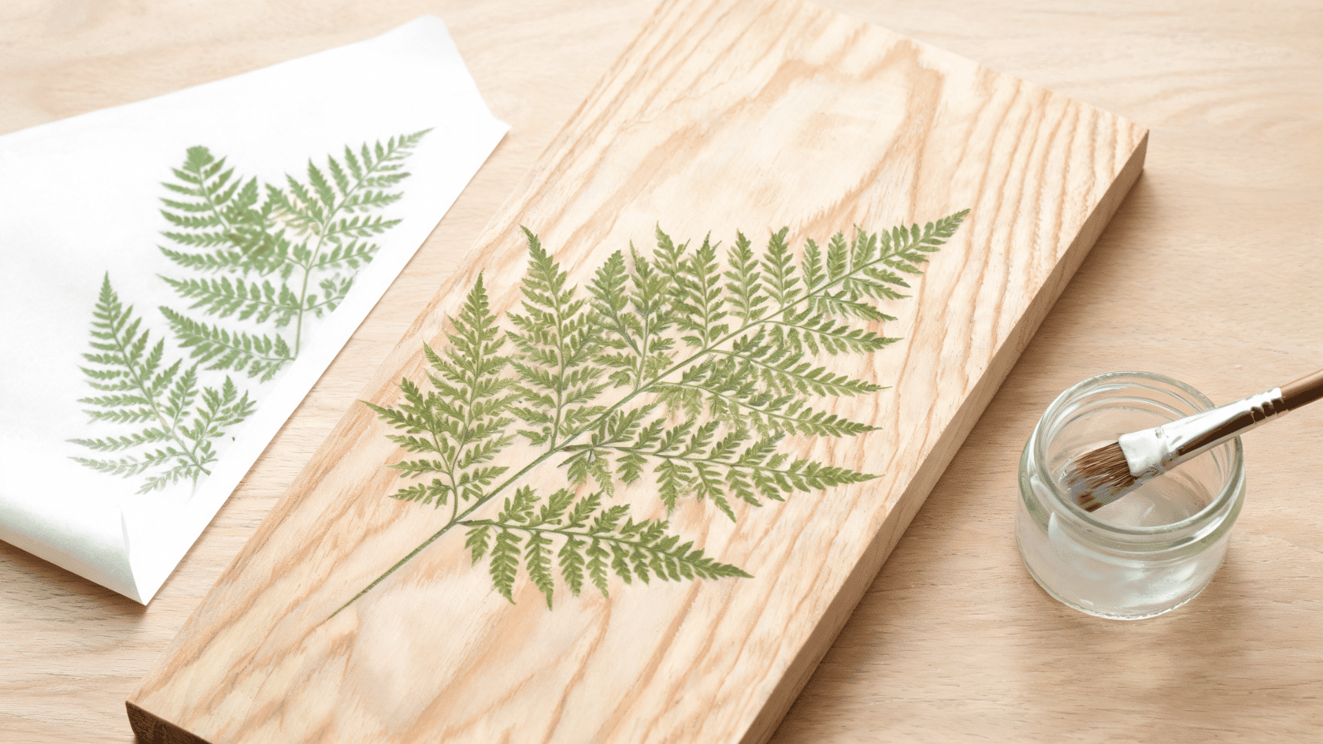 Print transfer on wood showing a fern design transferred onto a wooden board