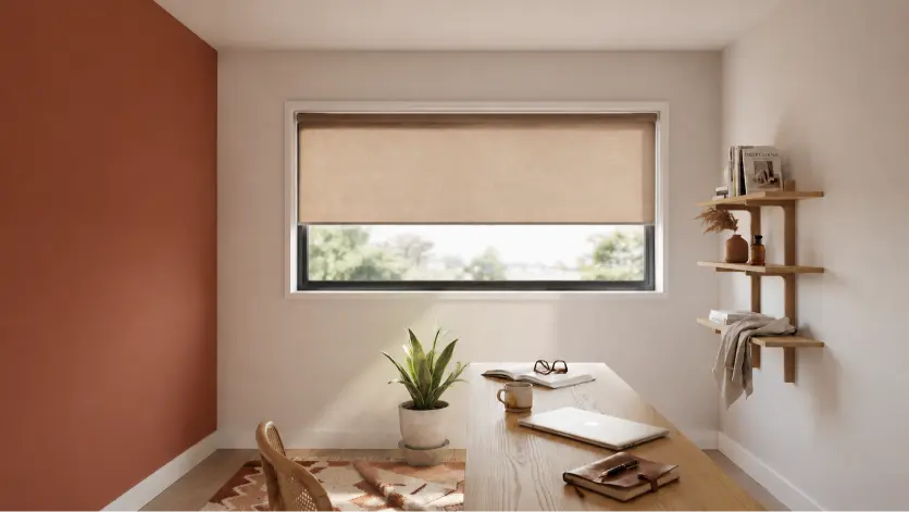 Minimal roller blinds in neutral tones covering a large window in a clean, modern minimalist workspace with soft lighting.