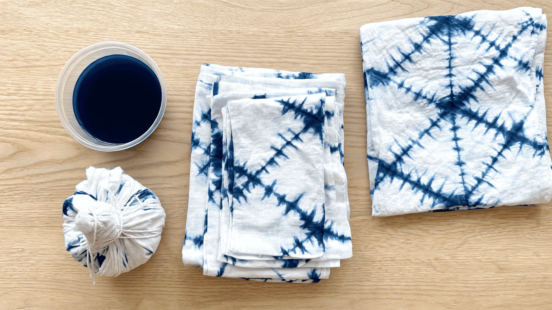 Shibori dyeing showing folded fabric with blue patterns, and tied cloth