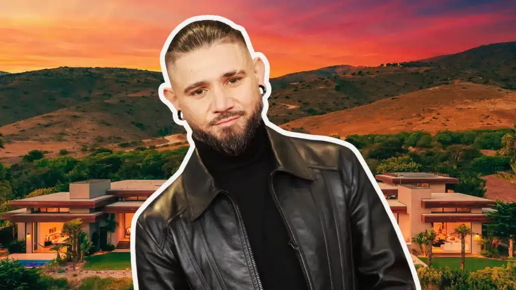 Skrillex in a leather jacket in front of his Malibu mansion at sunset with California hills behind.