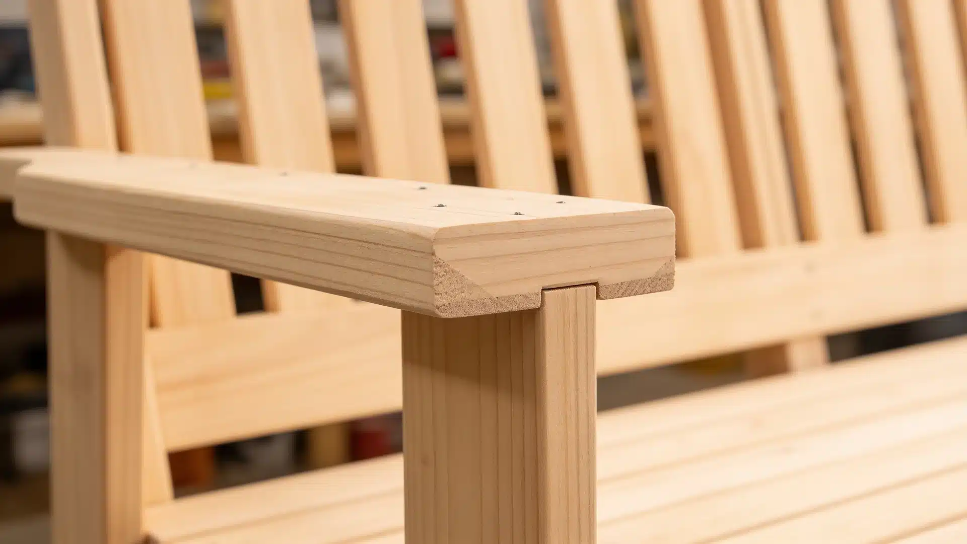 Lowest DIY porch swing back slat with rectangular corner notch fitting flush over armrest upright showing clean joint.