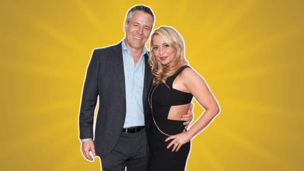 Tara Strong with her partner against a simple background.