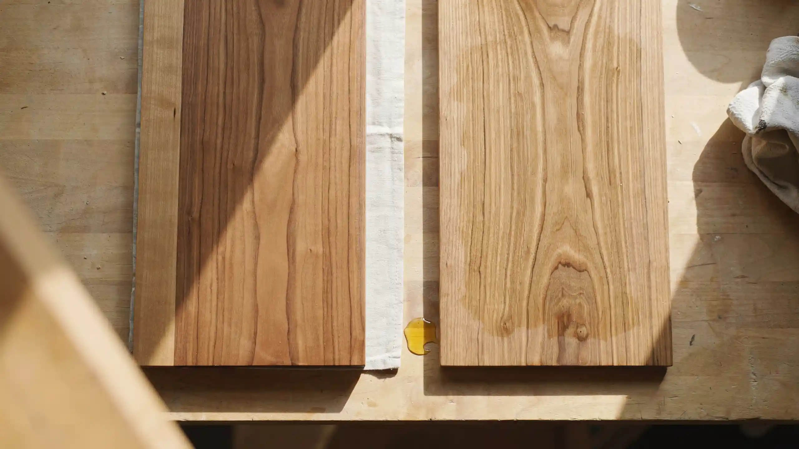 Two wooden boards comparing synthetic versus natural wood finish in matte and glossy surface side by side.