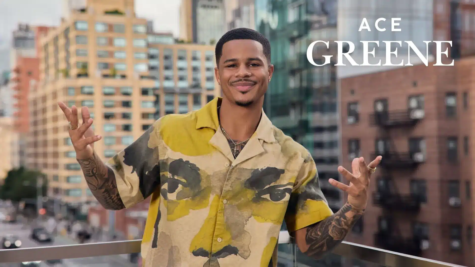 Ace Greene posing on a balcony with city buildings behind him and his name.
