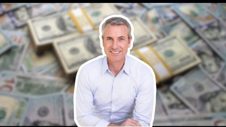 Andy Byron image in front of a blurred background of stacks of US dollar bills.