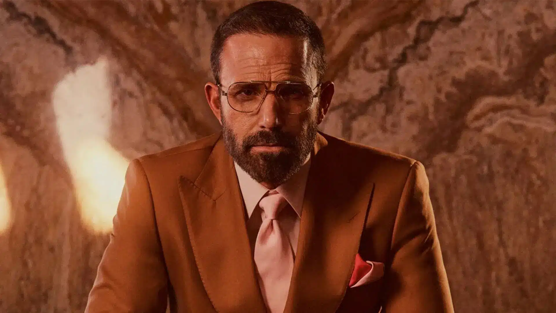 Ben Affleck wearing a brown suit and glasses