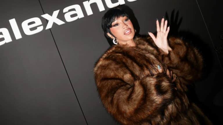 Cardi B wearing a large brown fur coat and posing at a red carpet or entertainment event