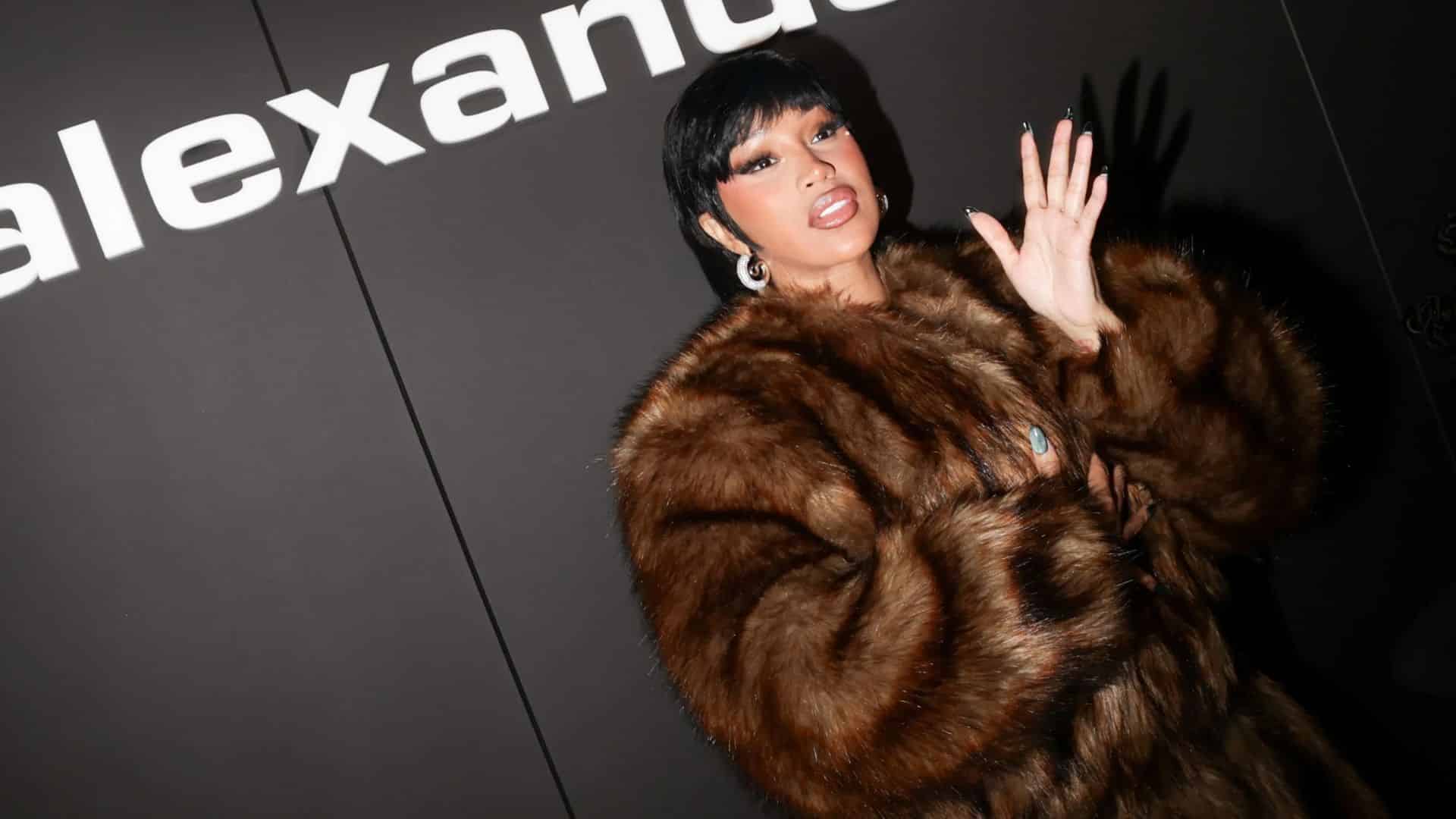 Cardi B wearing a large brown fur coat and posing at a red carpet or entertainment event