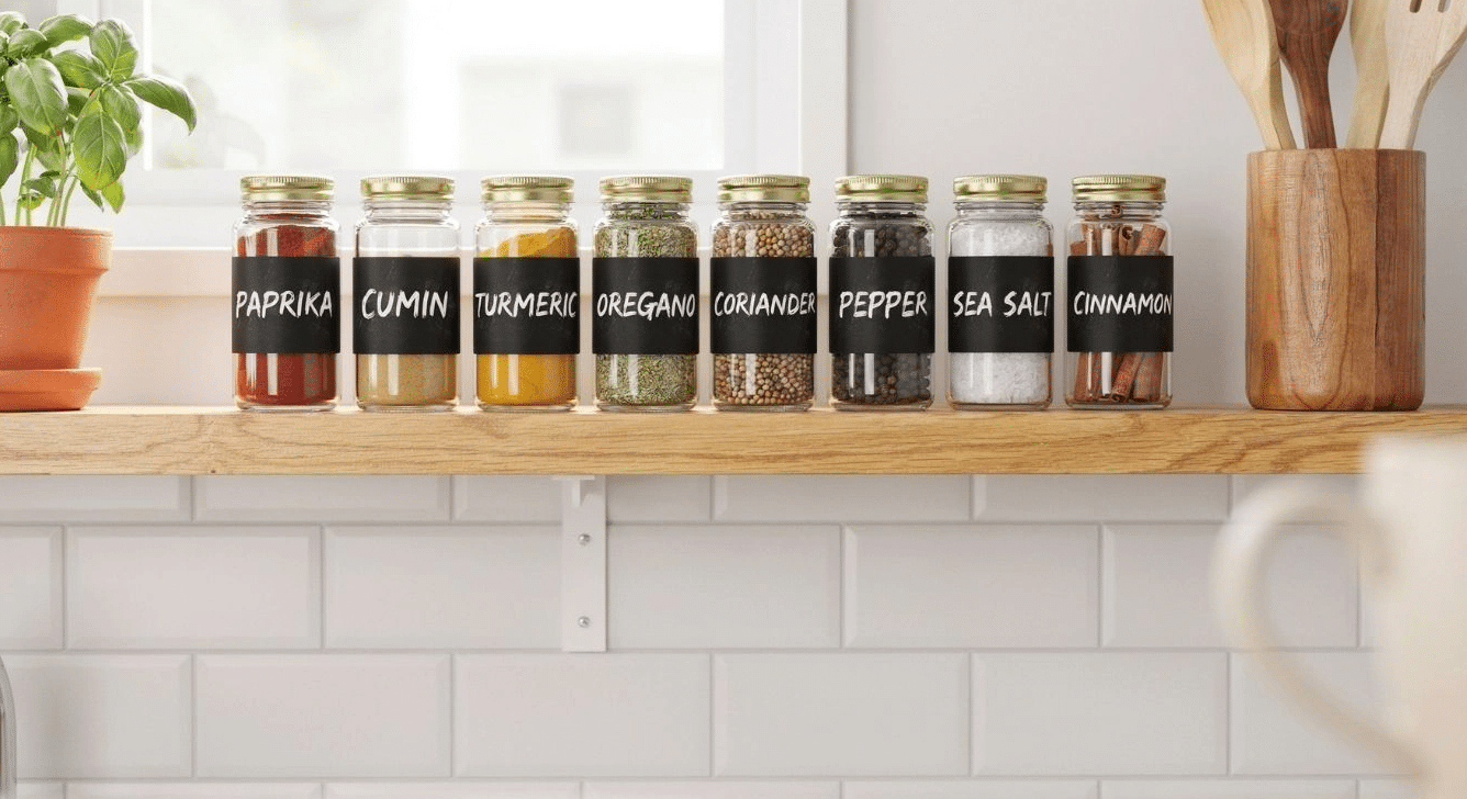 Chalkboard-labeled spice jars lined up on a kitchen shelf