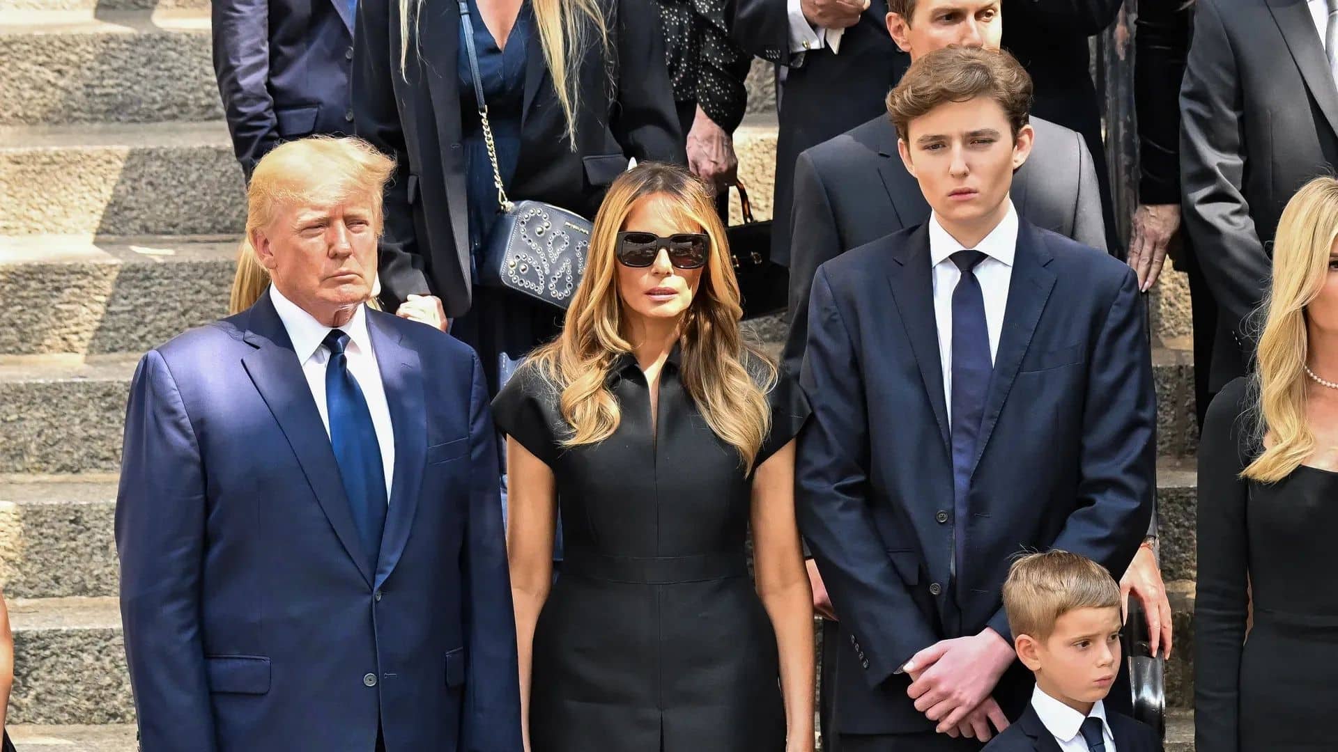 Donald, Melania, and Barron Trump standing together at a public event