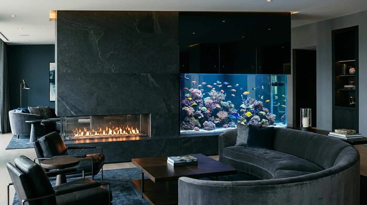 Modern fireplace wall with built-in aquarium beside a glowing fireplace.