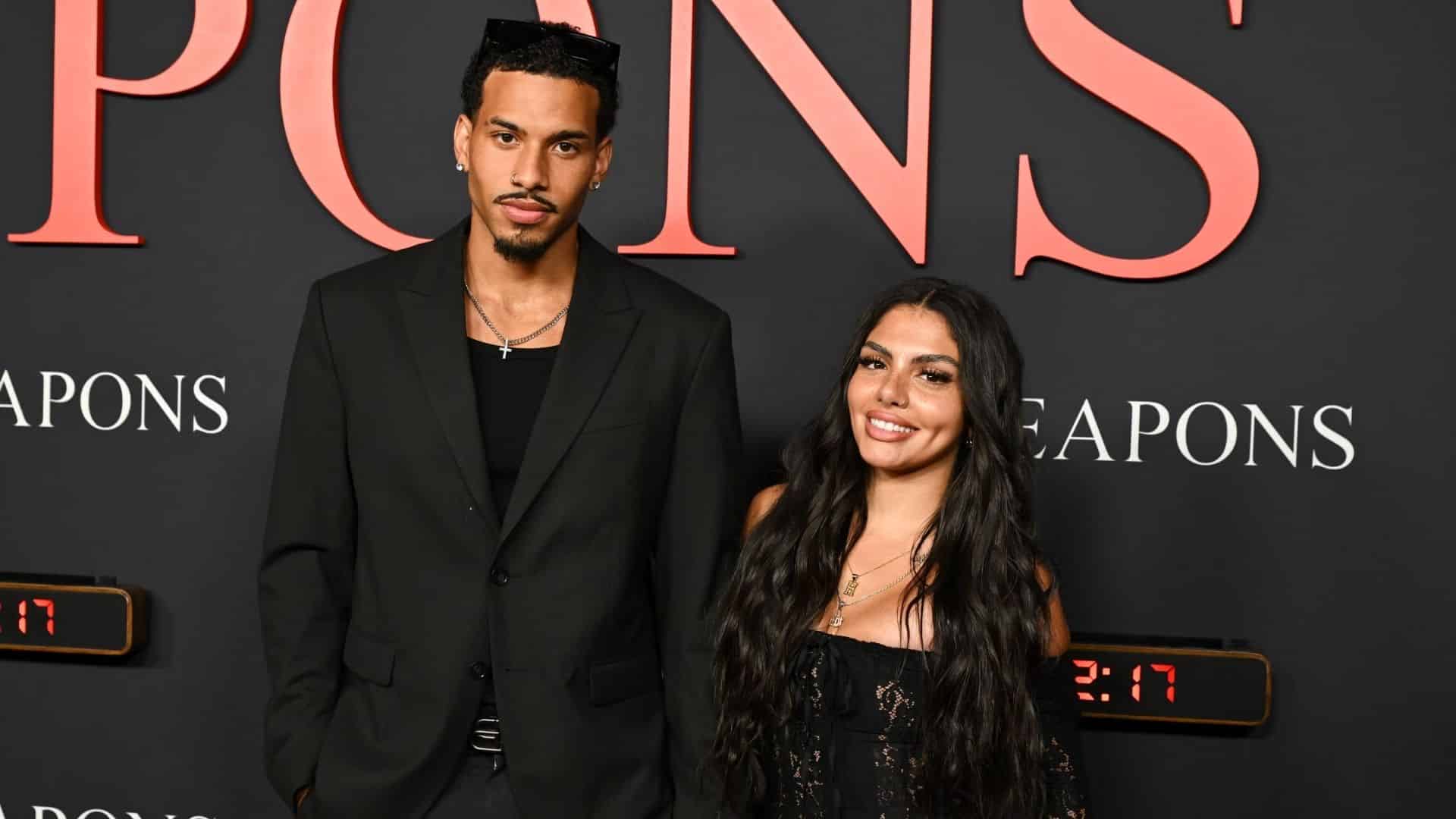 Huda Mustafa and Louis Russell pose together at a red carpet event.