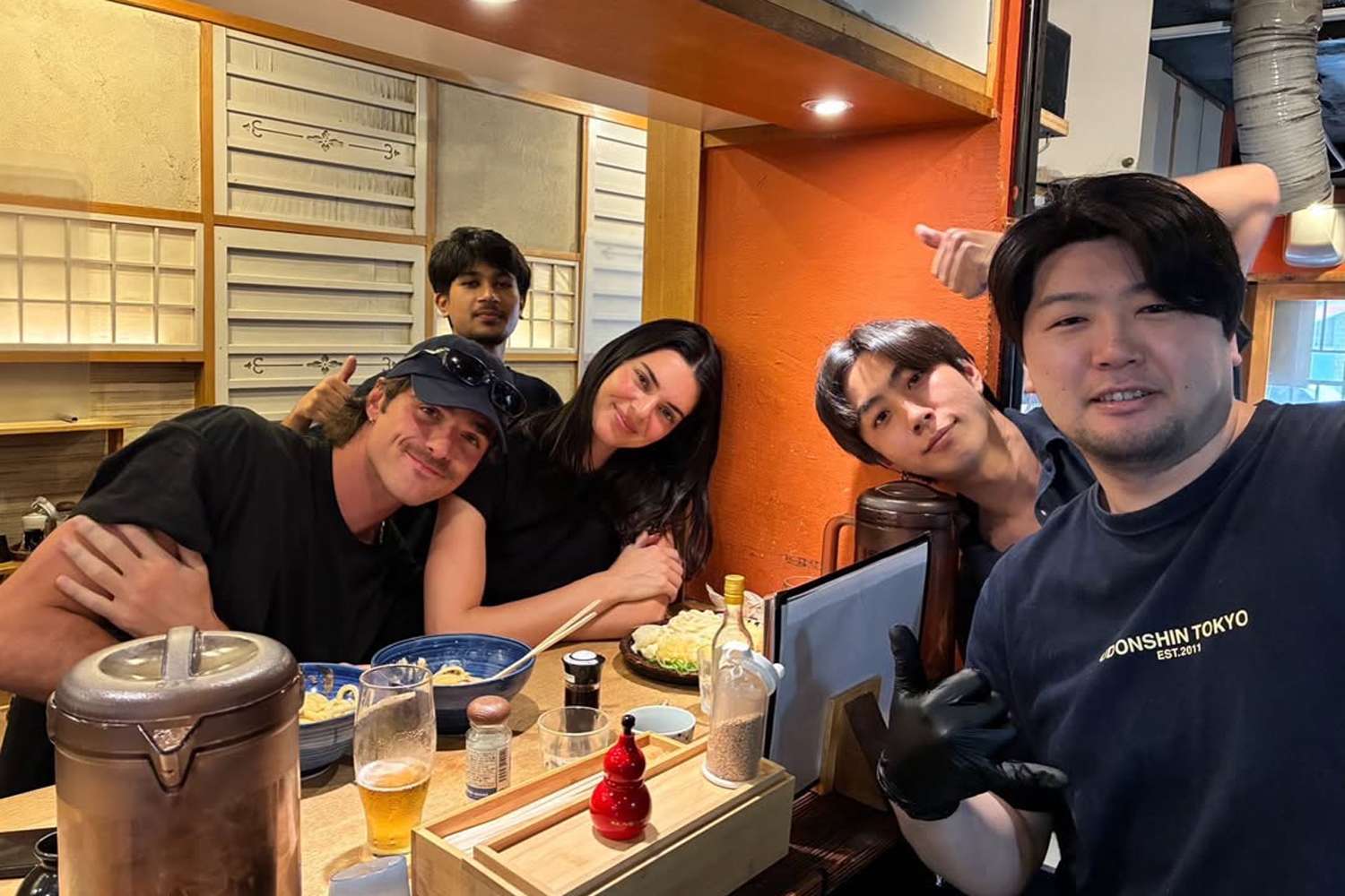 Jacob Elordi and Kendall Jenner posing with restaurant staff while dining in Tokyo.