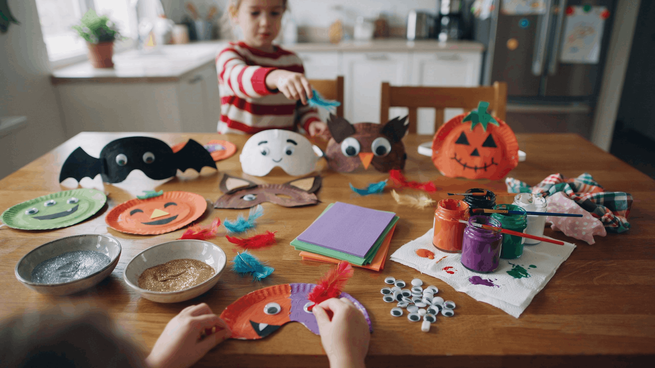 Kids creating homemade Halloween masks with craft supplies