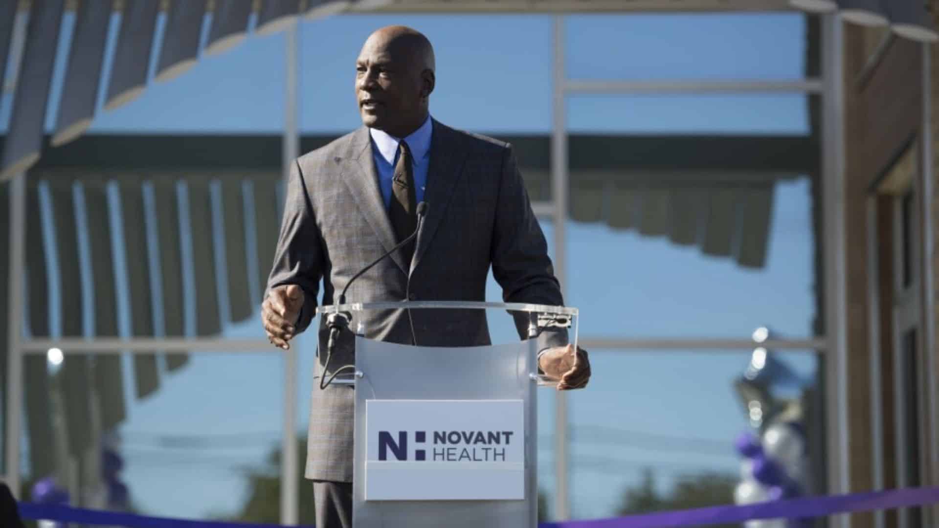 michael jordan speaking at a Novant Health podium outside a medical facility.