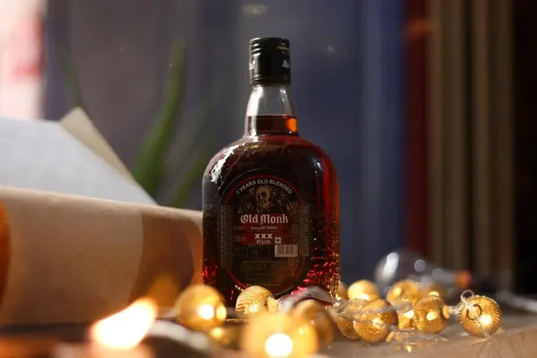 Bottle of dark rum with string lights on festive table in soft lighting