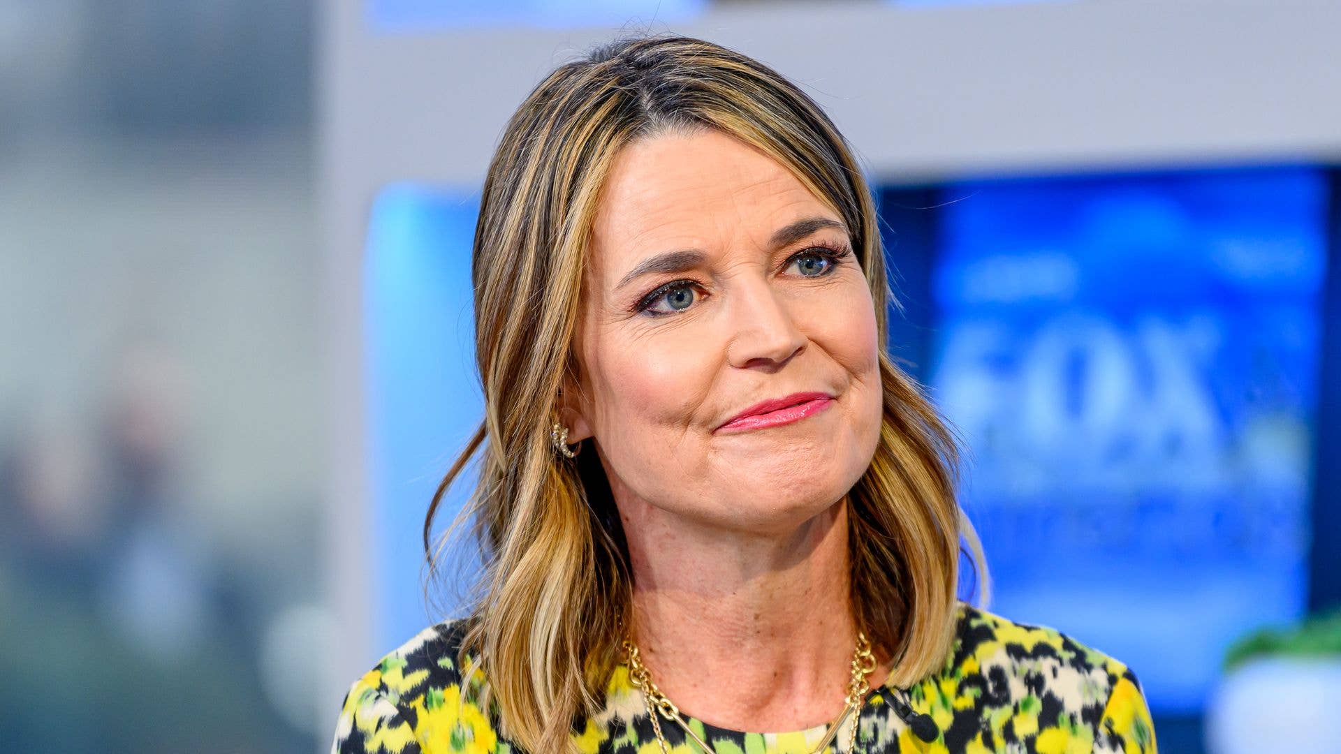 Savannah Guthrie speaking at an event in a yellow patterned dress