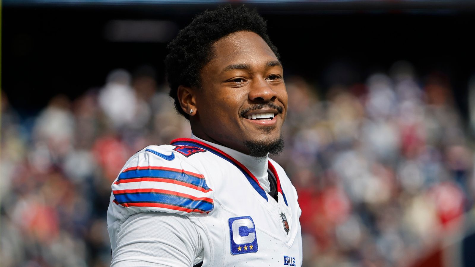 stefon diggs in jersey in a stadium with blur background.