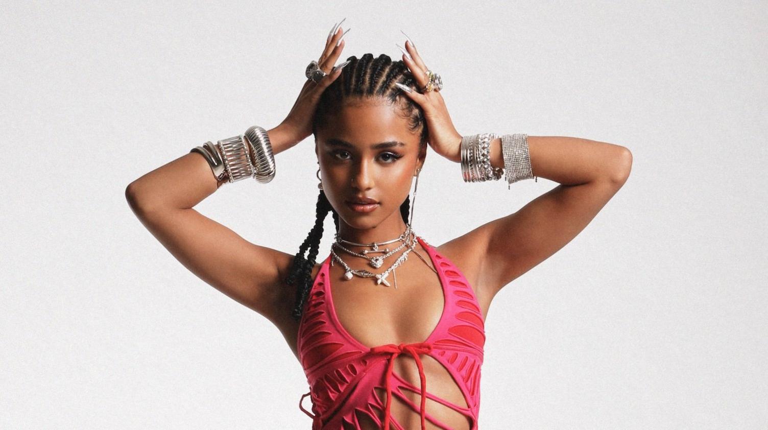 tyla wearing a pink dress, posing for the camera with a plain background
