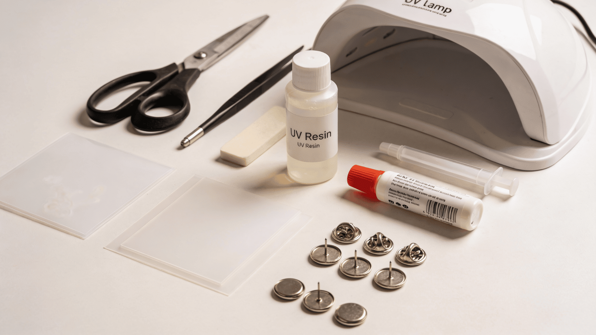 DIY enamel pin supplies including shrink plastic, UV resin, scissors, markers, pin backs, and a UV lamp.