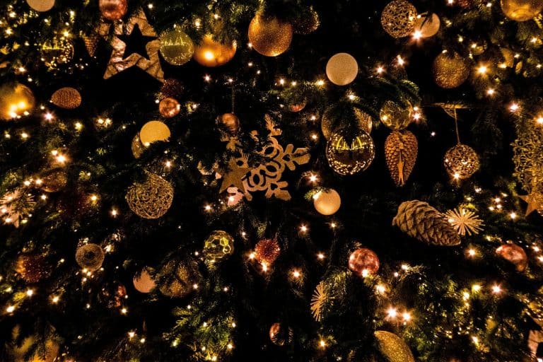 Christmas tree adorned with golden ornaments and glowing lights in festive setting