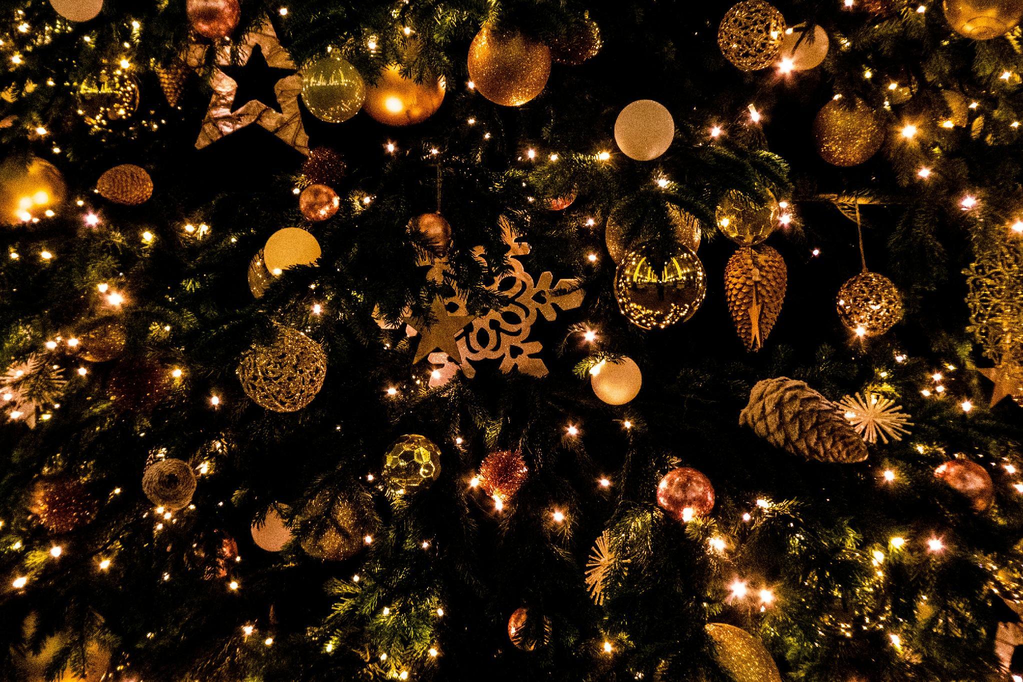 Christmas tree adorned with golden ornaments and glowing lights in festive setting