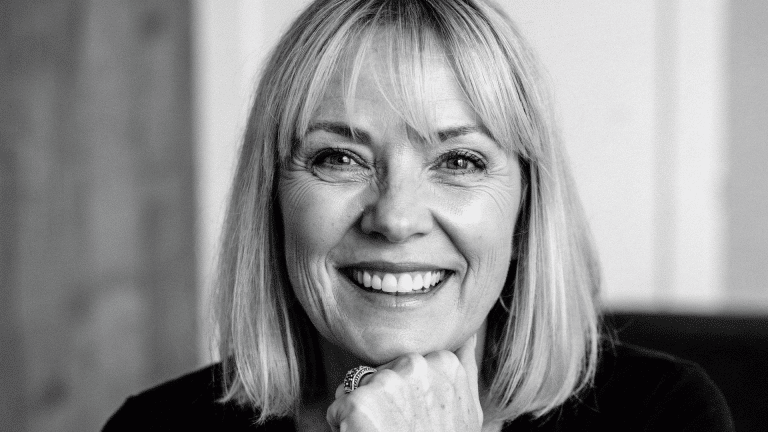 Black and white portrait of Christine McVie smiling with shoulder-length hair