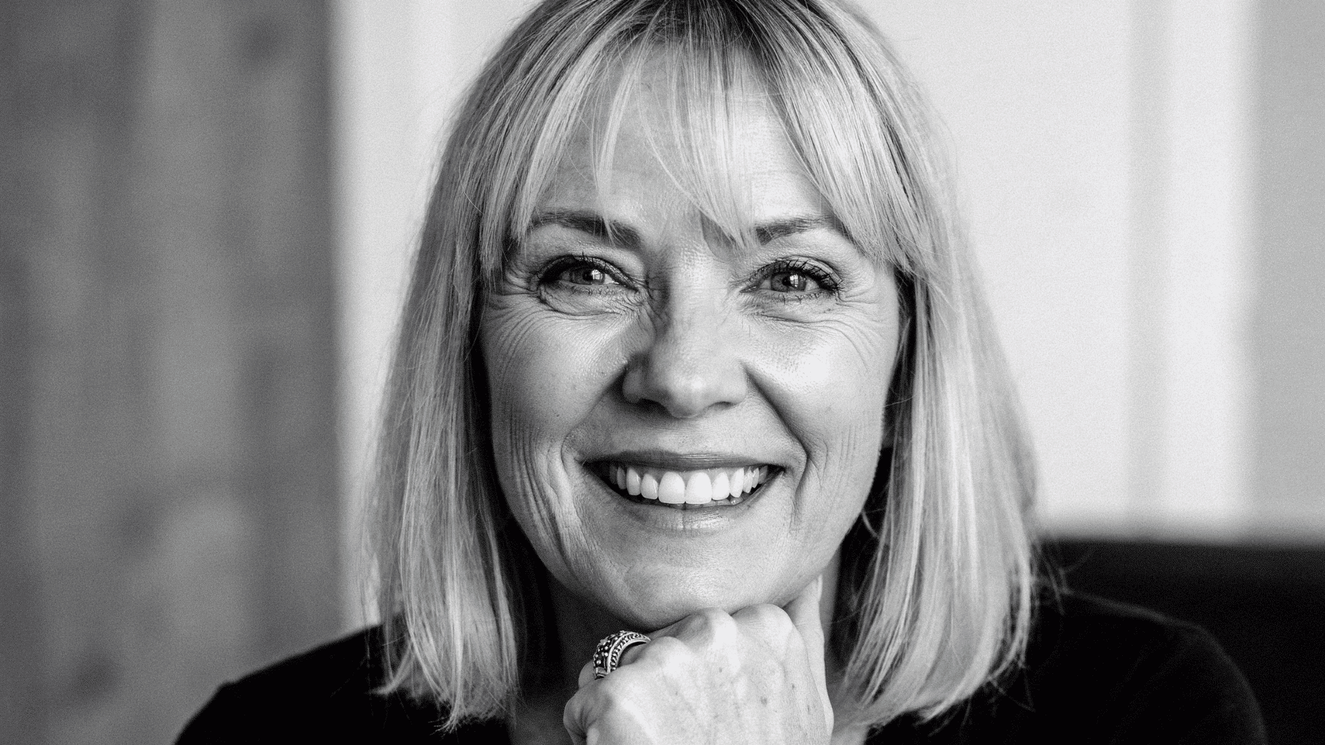 Black and white portrait of Christine McVie smiling with shoulder-length hair