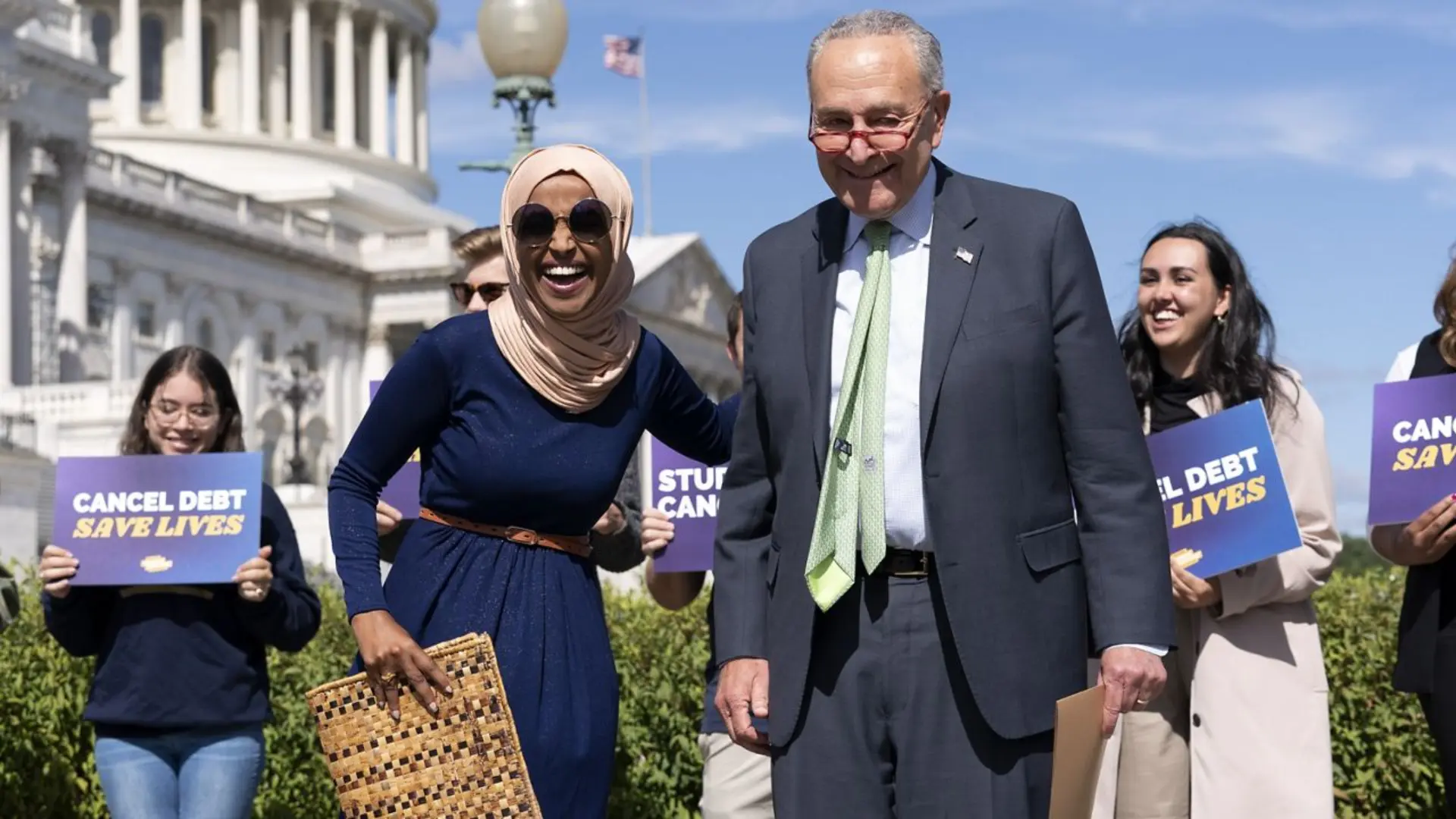 Representative Ilhan Omar standing alongside Senate Majority Leader Chuck Schumer outside the U.S. Capitol