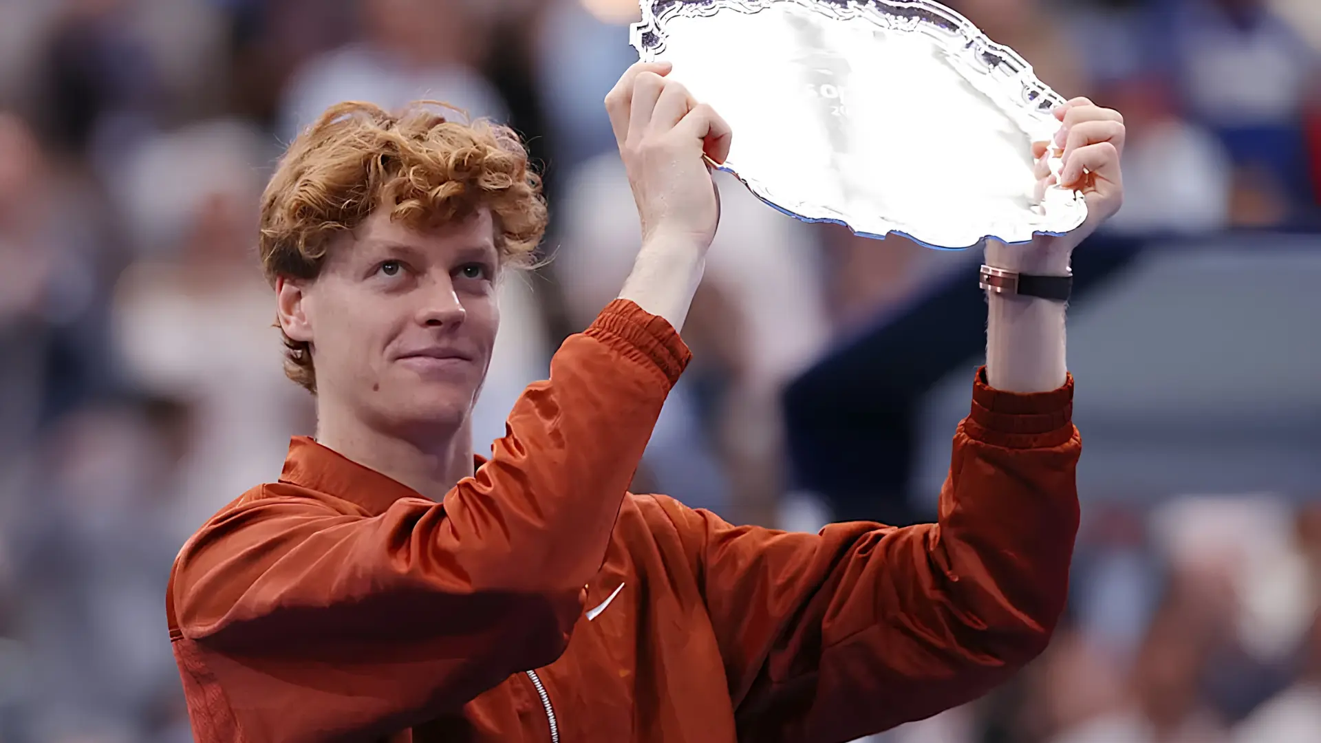 Jannik Sinner celebrating with trophy after winning a major tennis championship match.