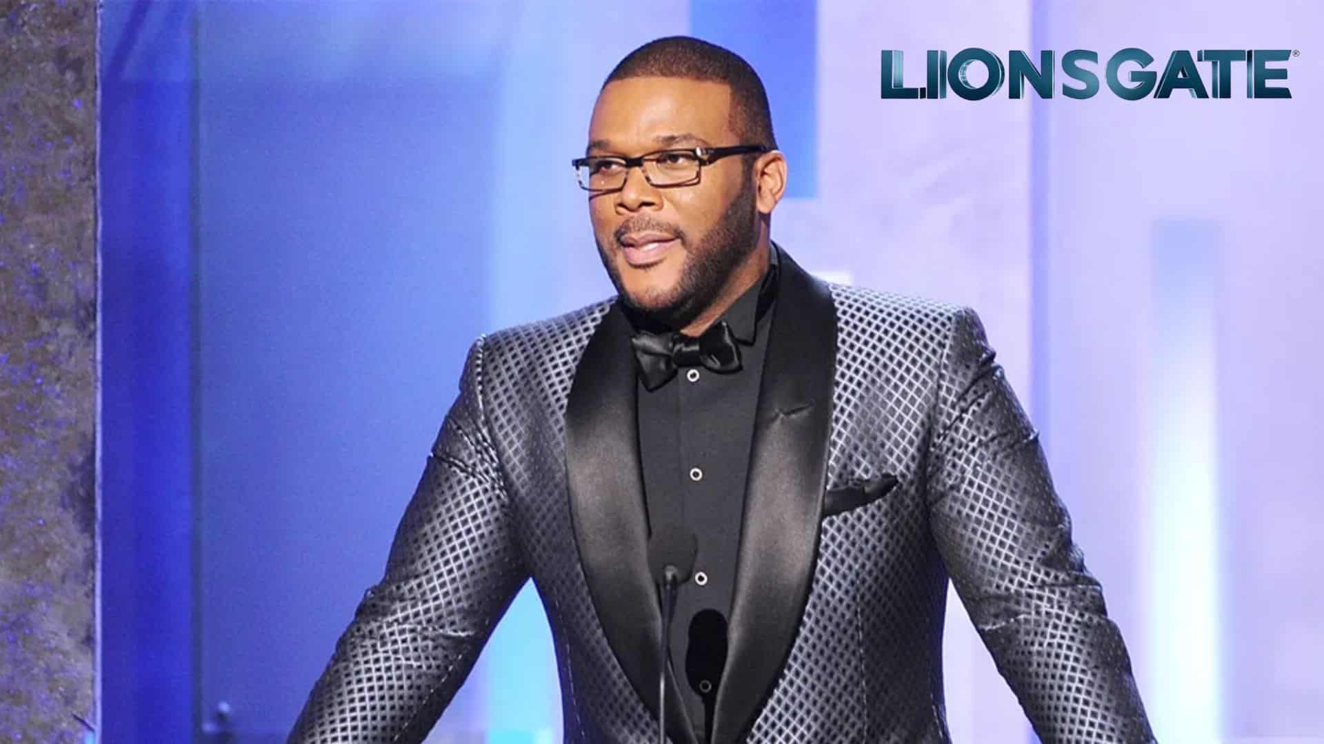 Tyler Perry in a suit at an event against the Lionsgate logo