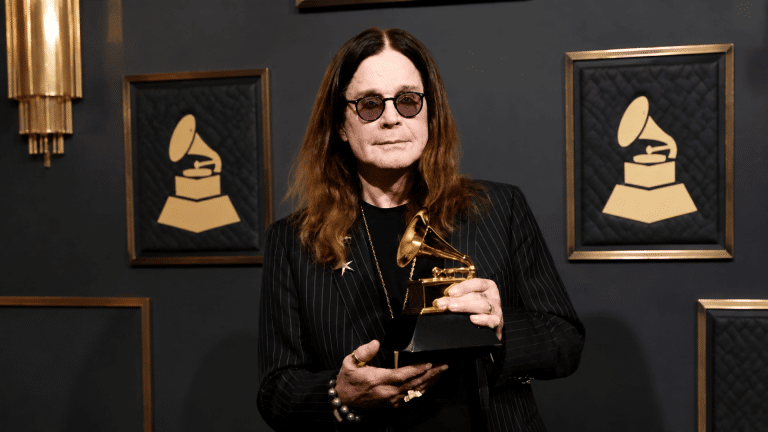 Ozzy Osbourne net worth feature image showing the singer with a Grammy award.