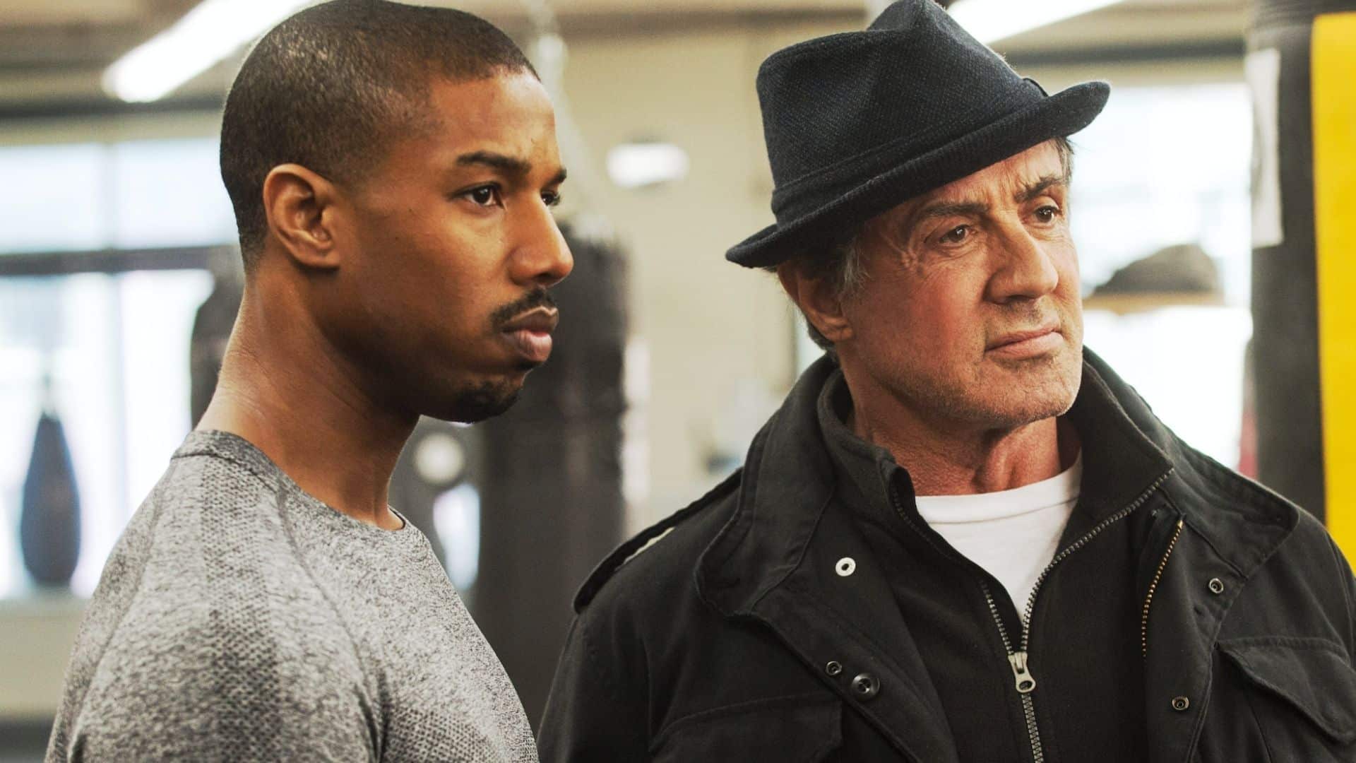 Sylvester Stallone with Michael B. Jordan during a Creed film scene showcasing his producer role.