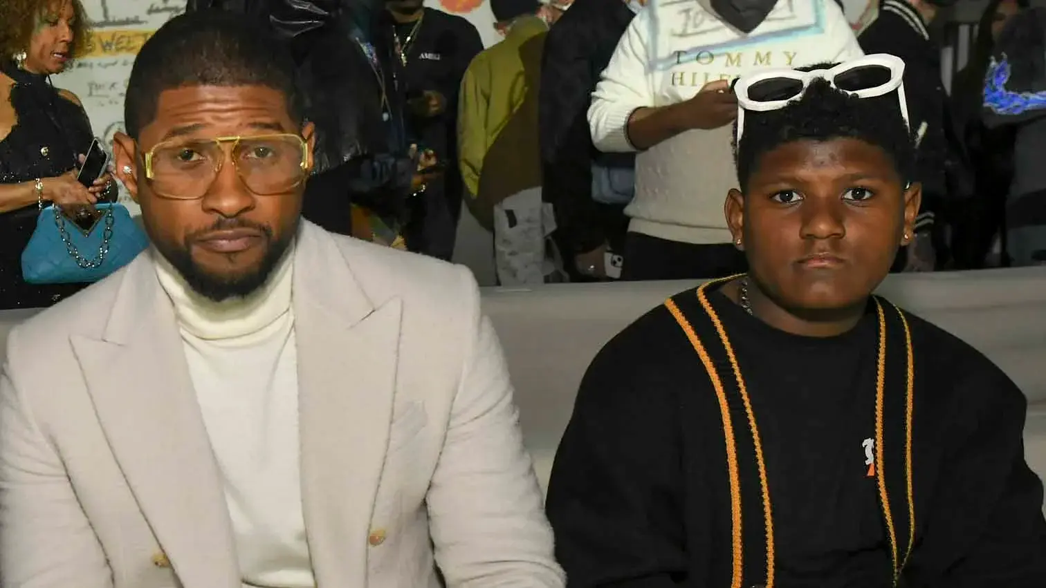Usher sitting beside his second son, Naviyd, at a public event.