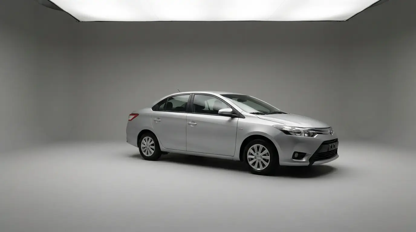 Silver sedan parked in a professional photography studio with soft lighting and neutral background